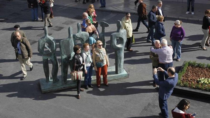 Un grupo de turistas se fotografía delante de una de las esculturas de Elena Laverón, en la plaza Costa del Sol de Torremolinos.