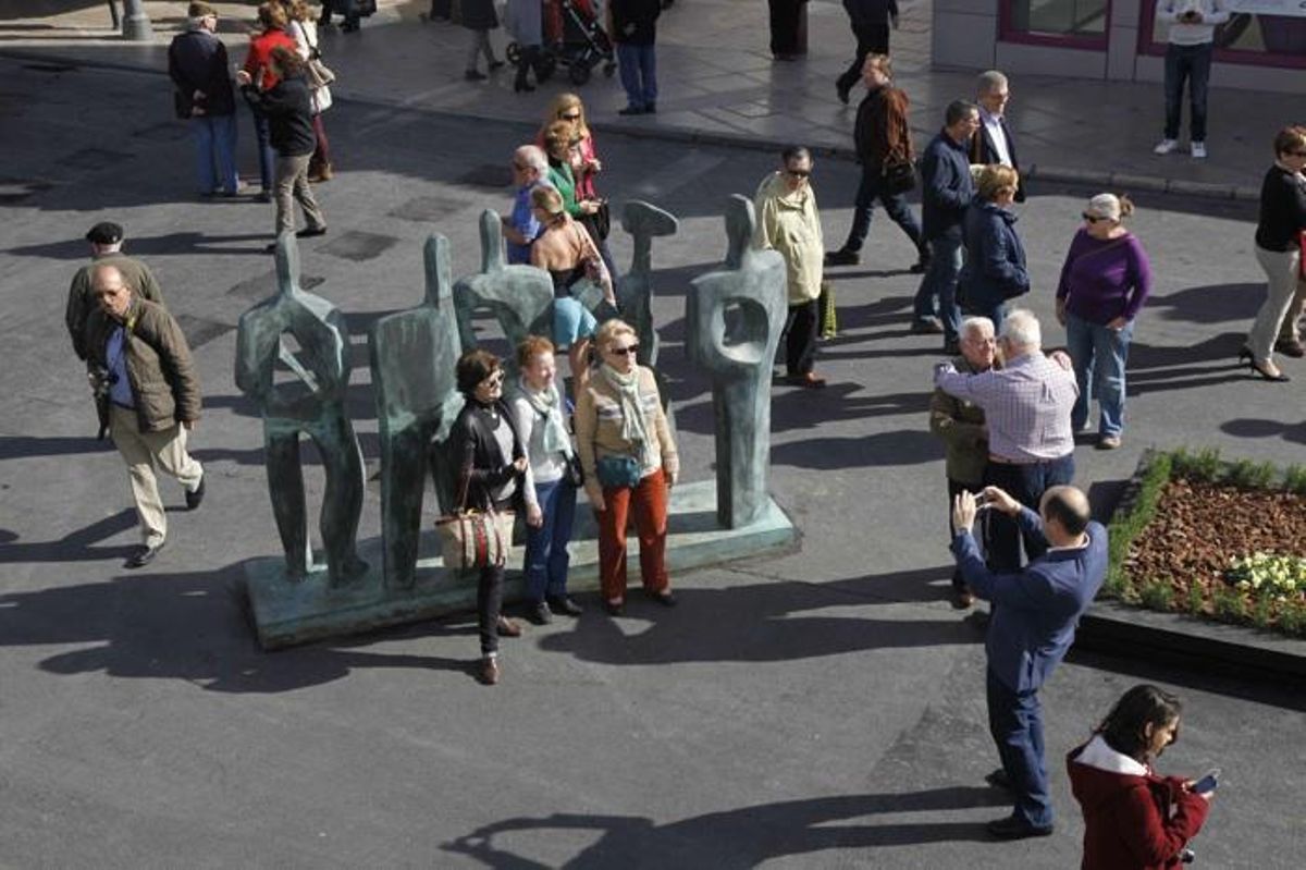 Un grupo de turistas se fotografía delante de una de las esculturas de Elena Laverón, en la plaza Costa del Sol de Torremolinos.