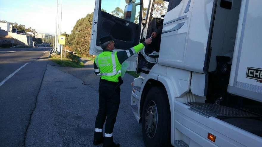 Un agente de Tráfico pide la documentación a un camión durante un control. // FdV