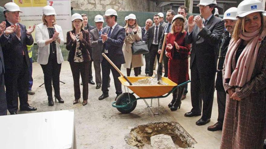 Báñez y Pastor colocan la urna con prensa del día y monedas en un hueco excavado en el solar. // Marta G. Brea