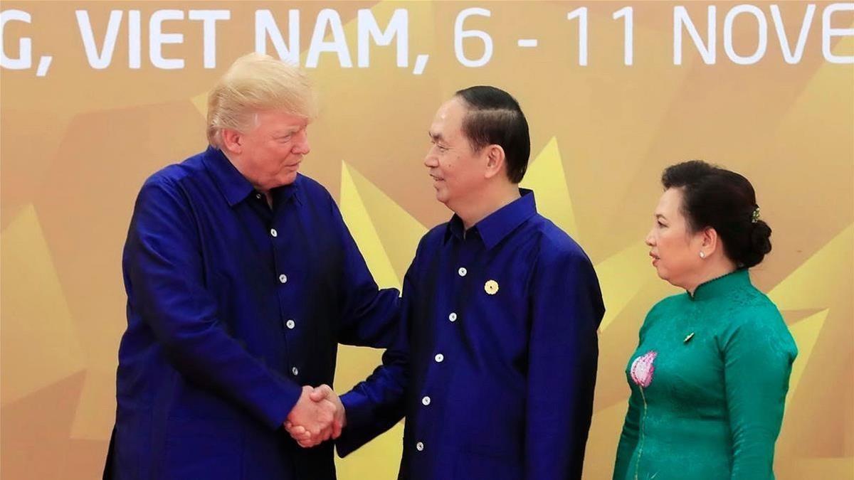 Trump (izq) estrecha la mano del presidente de Vietnam, Tran Dai Quang, junto a su esposa, en la cumbre de la APEC, el 10 de noviembre.