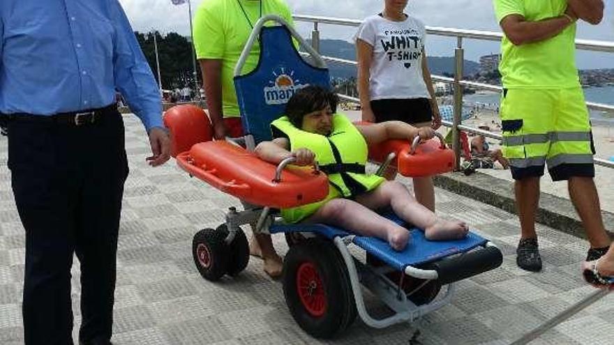 Caballero, ayer, en Samil, con una usuaria del servicio de sillas para personas de movilidad reducida. // Faro