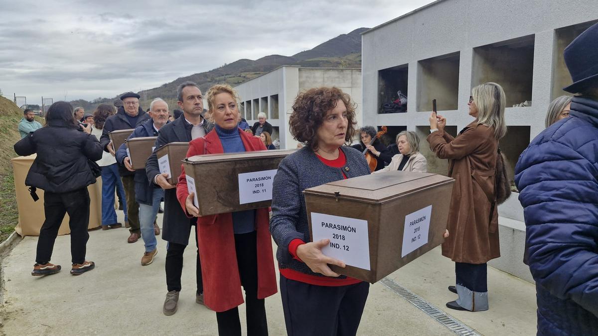 Beatriz González Prieto, Gema Álvarez y Ovidio Zapico, junto a otras personas, con las cajas con restos de los asesinados en Parasimón