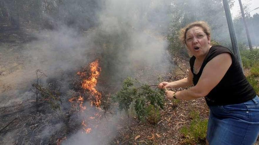 Una mujer trata de contener las llamas.