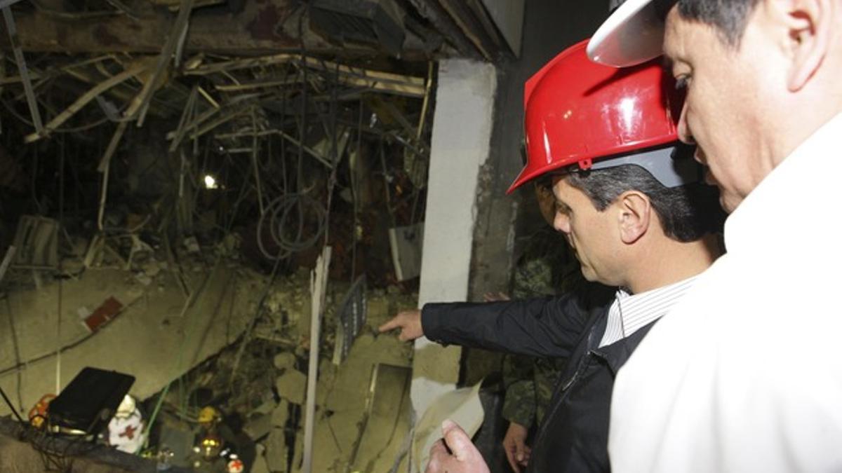 El presidente de México (derecha) observa los daños causados por la explosión en la sede de Pemex, esta madrugada.