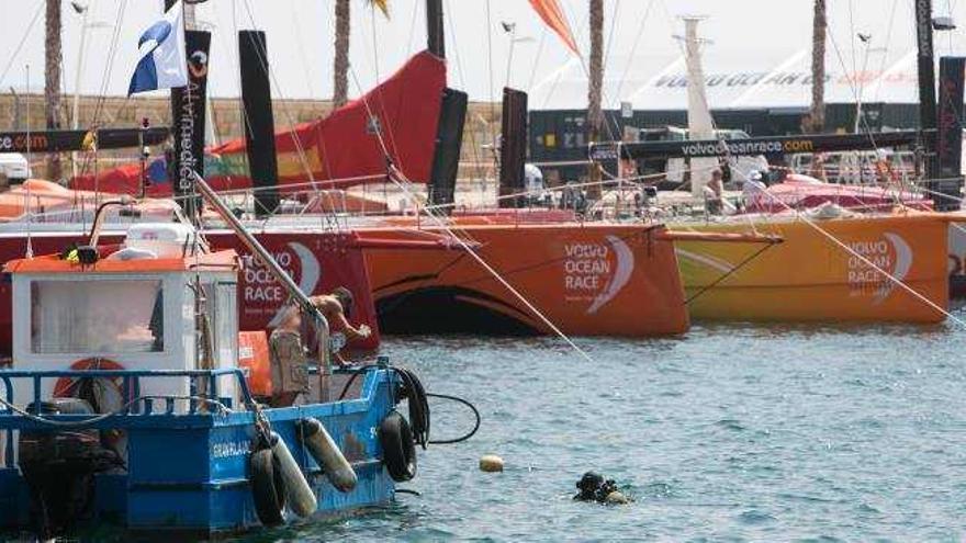 Un buzo realiza tareas de mantenimiento ante los barcos que participan en la regata de la Vuelta del Mundo a Vela