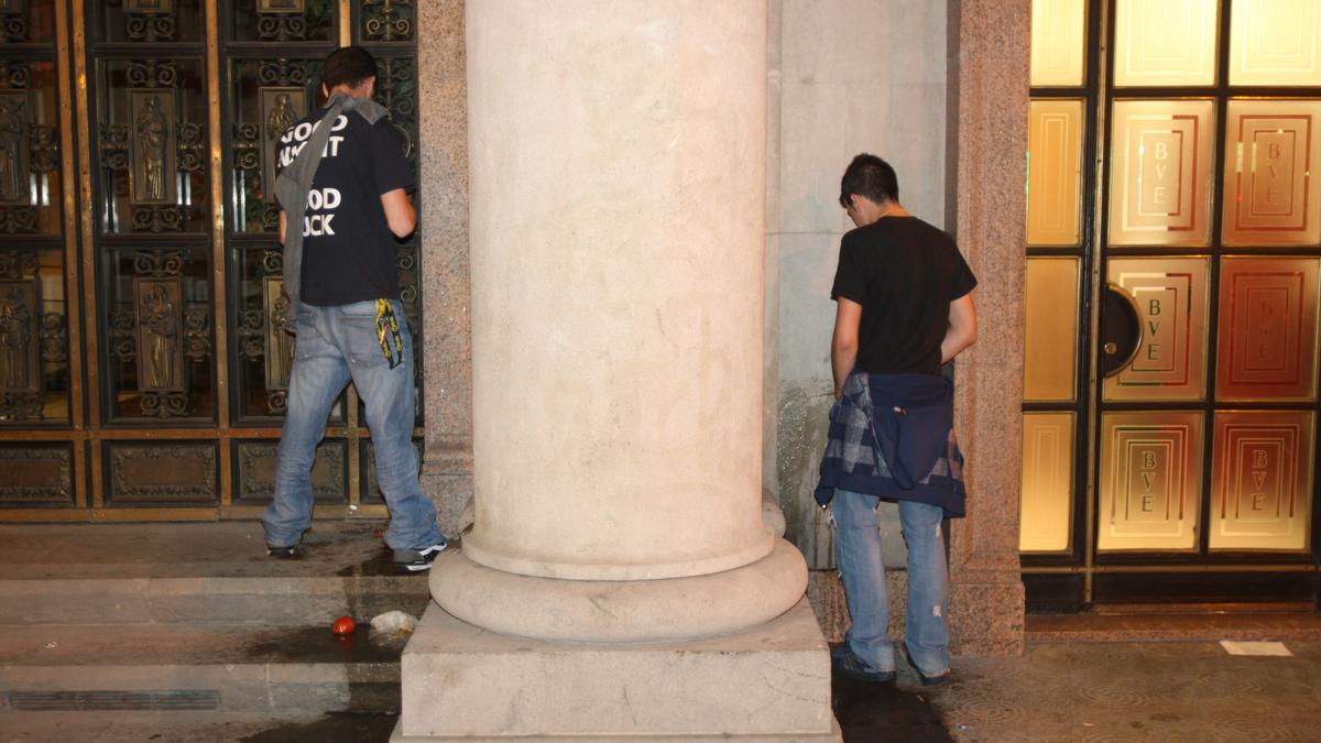 Dos chicos orinan en unos portales de la Gran Via de Barcelona.