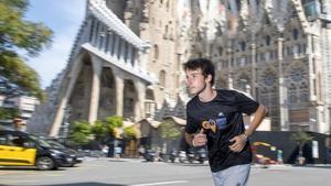 Luca Lande, el joven guía que muestra la ciudad mientras practica el ’running’ con turistas, corre junto a la Sagrada Familia.