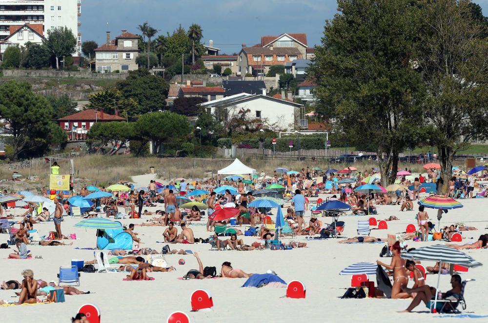 Bañistas disfrutando del buen tiempo en la playa de Samil. // Marta G. Brea