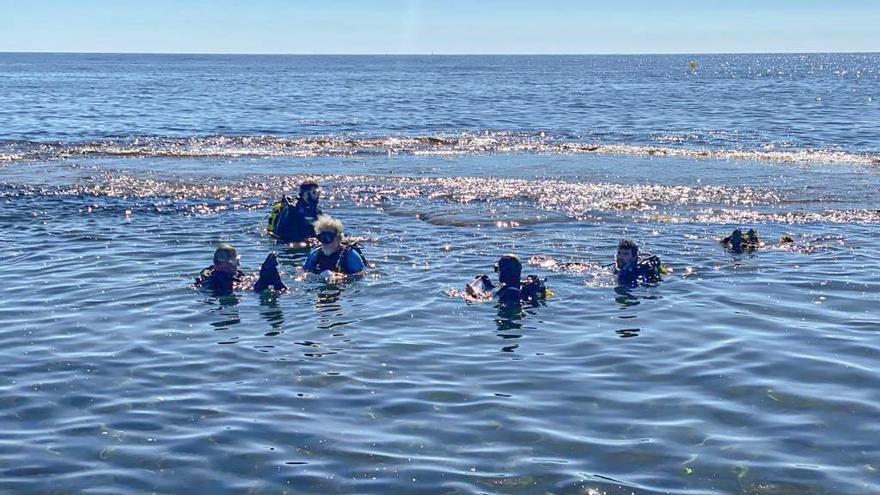 Buzos al final de la playa del Carabassí tratando de recoger residuos que acaban en el mar