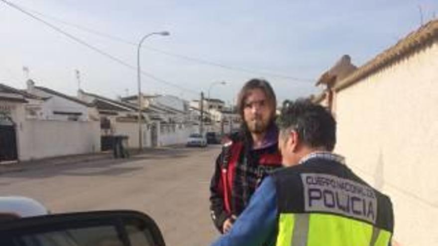 Un policía traslada al detenido en Torrevieja.