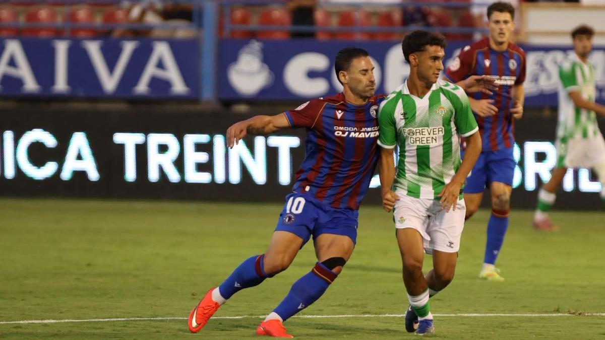 Kike Márquez pugna con un jugador del Betis Deportivo durante el Trofeo de la Cordialidad.