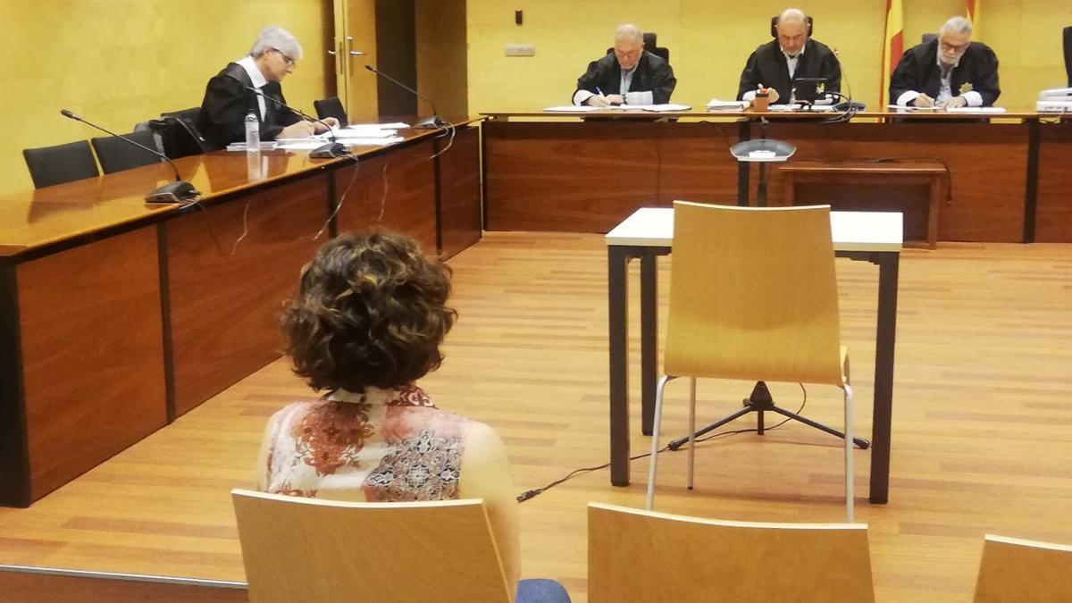 D'esquenes, l'acusada de falsificar el padró per cobrar la viudetat durant el judici a l'Audiència de Girona.