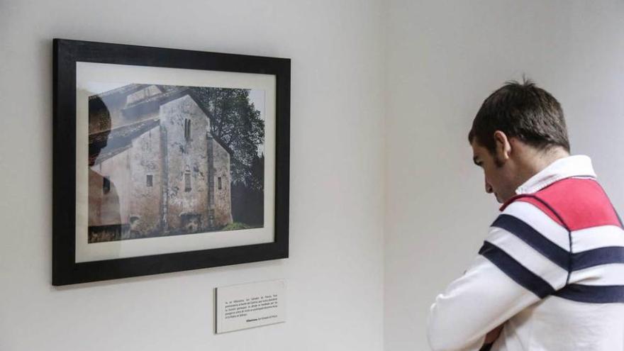 Un joven admira una foto de San Salvador de Priesca (Villaviciosa).