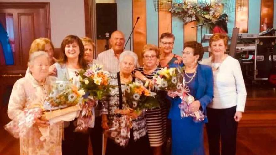 Las homenajeadas, con sus ramos de flores, junto a la alcaldesa, Amelia Fernández, y vecinos de Albandi.