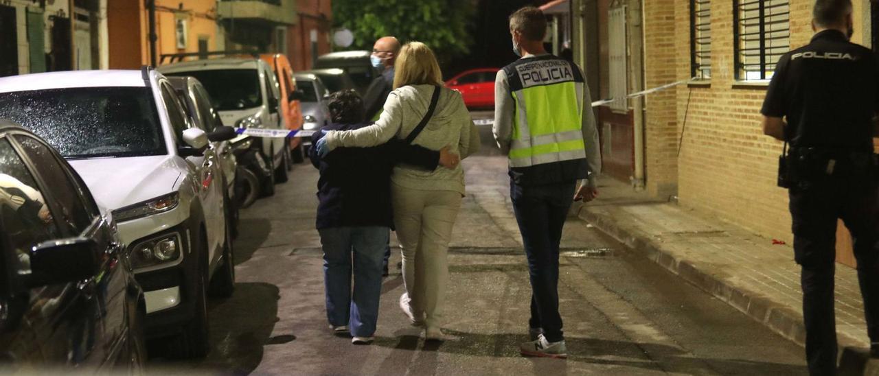 Una policía nacional consuela a un familiar de la mujer muerta a manos de su hijo, con una enfermedad mental, en Aldaia. | J. M. LÓPEZ