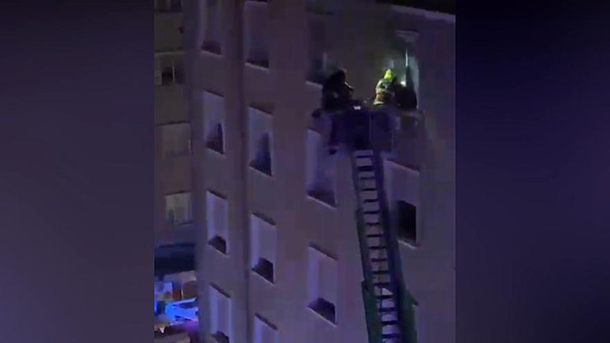 Momento en el que los bomberos se encaraman al piso desde la escalera extensible para rescatar al padre y a su hija.