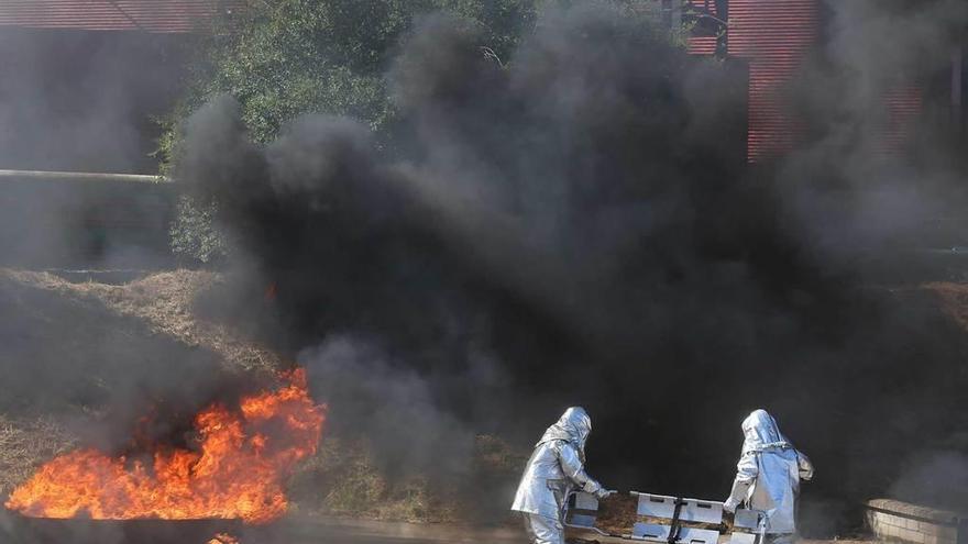 Dos bomberos con trajes de aproximación, ayer, en el simulacro de incendio en Arcelor.