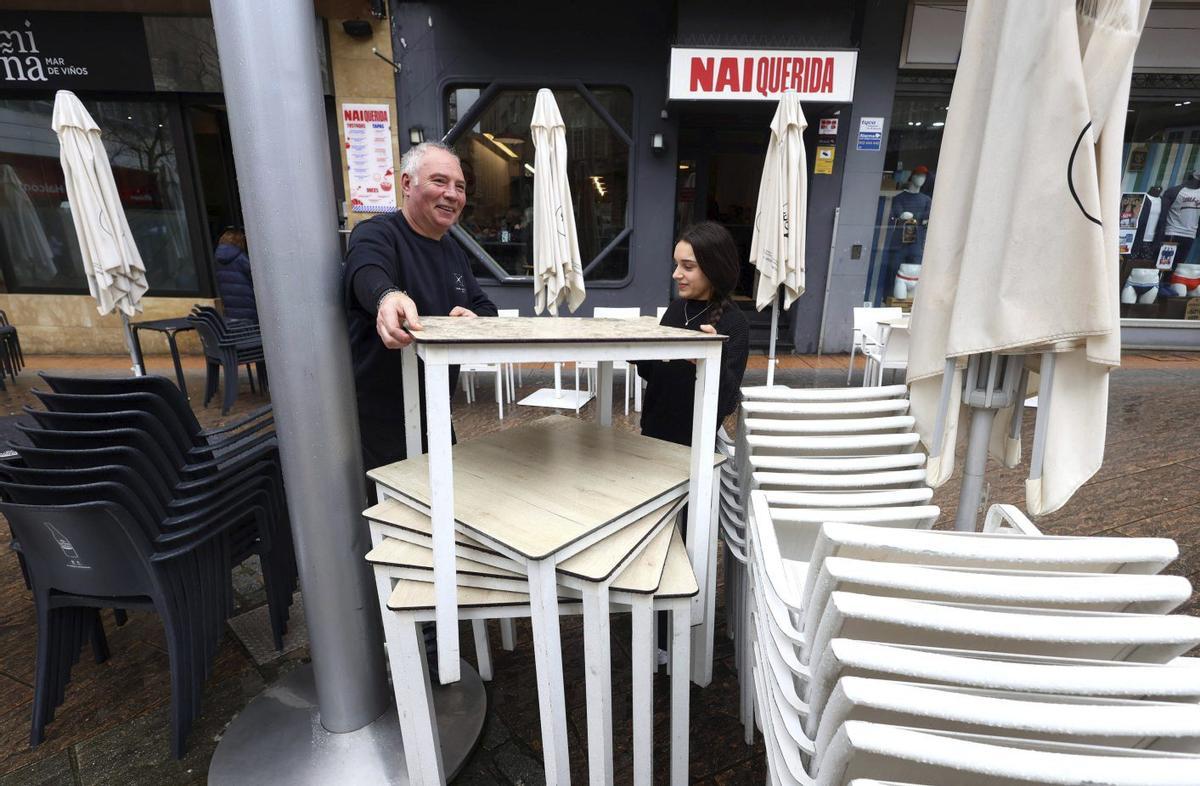 Jorge Pérez, encargado del «Miña» y «Nai Querida», recoge una terraza con una de las camareras.