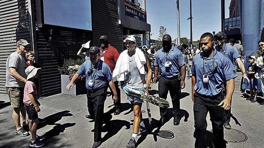 Nadal, protegido por guardaespaldas, se dirige a una pista para entrenar en el complejo de Flushing Meadows.