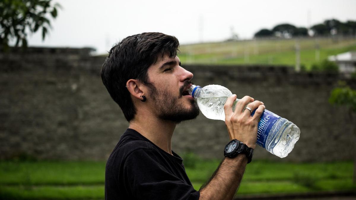 Un joven bebiendo agua.