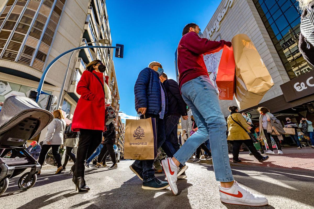 Varios clientes con bolsas de compras en la avenida de Maisonnave.