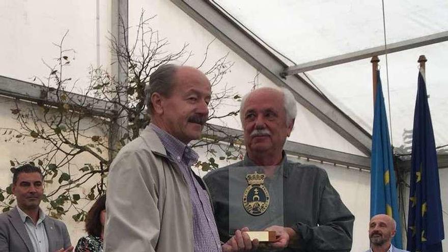 Luis Mier recibe de manos del concejal José Carbonell el premio al mejor expositor de la Feria de la miel, en Cangas de Onís.