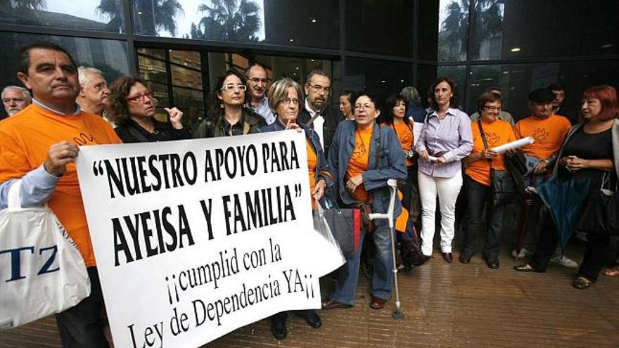 A la izquierda, miembros de la Plataforma por la Ley de Dependencia a las puertas del juzgado. A la derecha, el padre de la joven con parálisis cerebral que ha presentado la demanda con una camiseta de la Plataforma