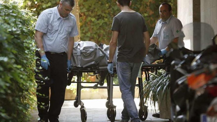 Los servicios funerarios durante el traslado de uno de los cadáveres.