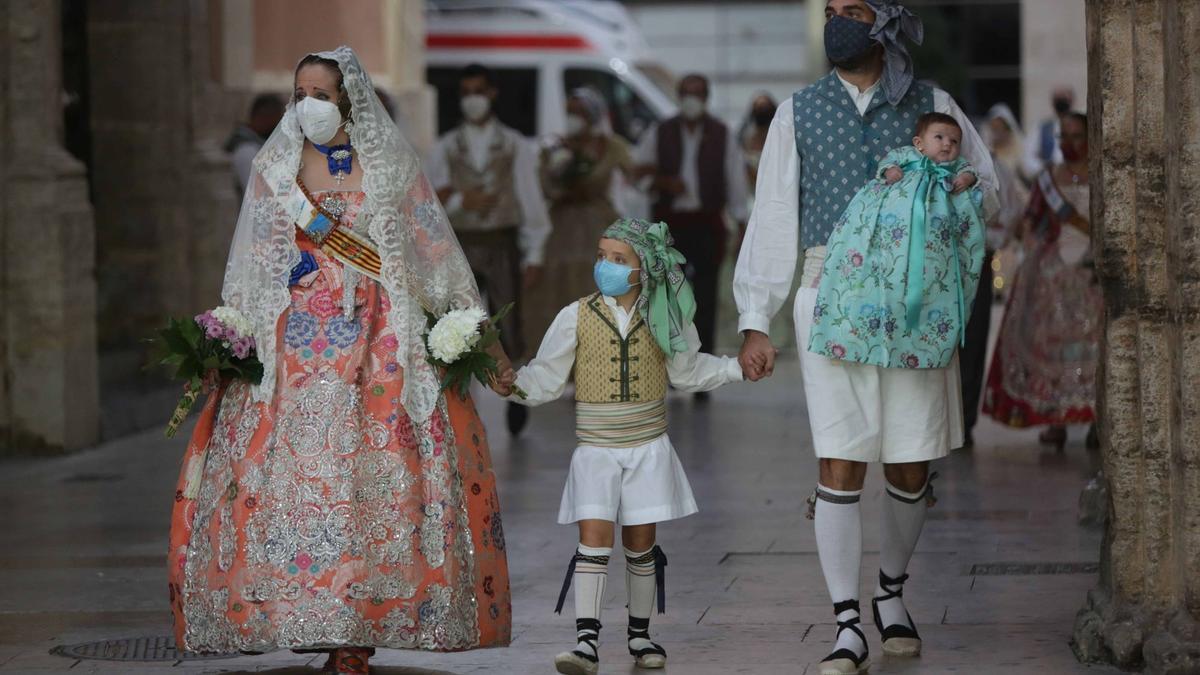 Ofrenda Fallas 2021: Una familia entra en la plaza de la Virgen para entregar sus flores a la Mare de Déu.