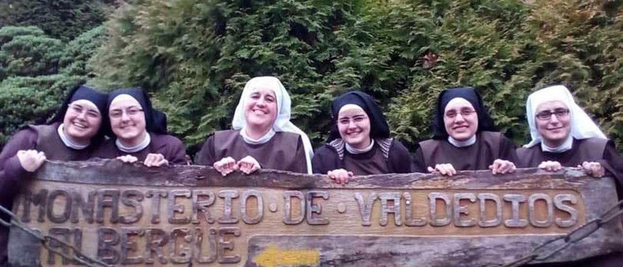 Las hermanas, junto al cartel del monasterio.