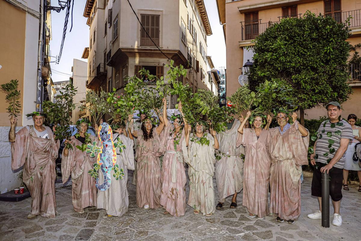 Vecinos de la Calatrava y Canamunt, muchos vestidos de verde y con ramas de árboles, se unen durante sus cercavilas para homenajear a los bellasombras talados en la plaza Llorenç Villalonga.