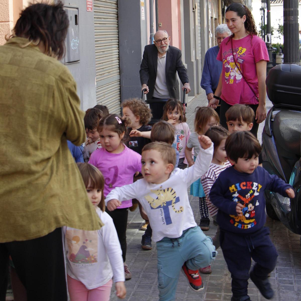 El poeta Marc Granell i les mestres de l'Escoleta el Trenet regalant poemes amb la xicalla pels carrers de Patraix.