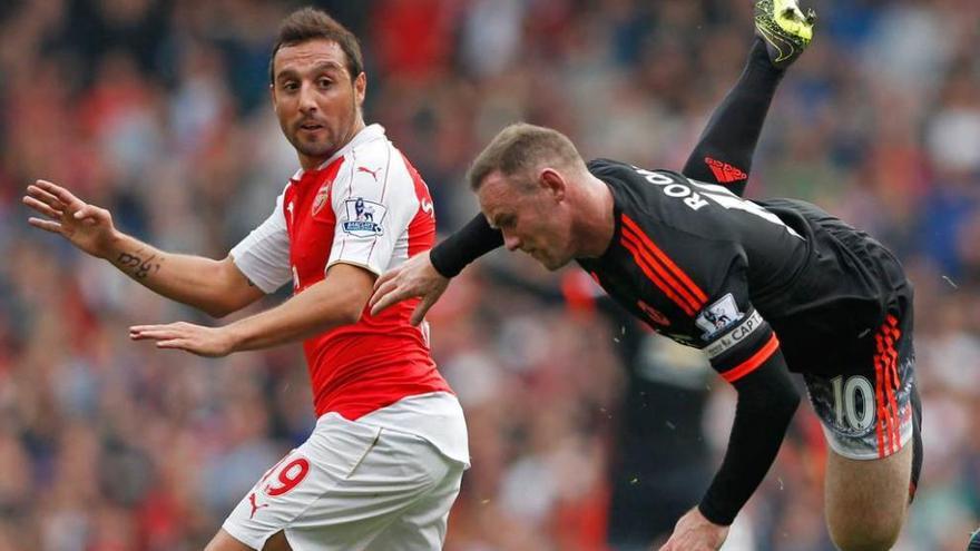 El asturiano del Arsenal Santi Cazorla observa la caída de Wayne Rooney, del Manchester United.