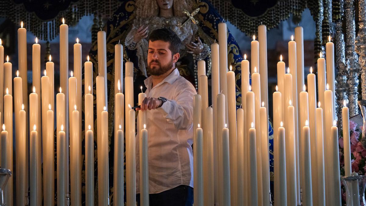 Un hermano de la Estrella prepara las velas del trono de María Santísima de la Estrella