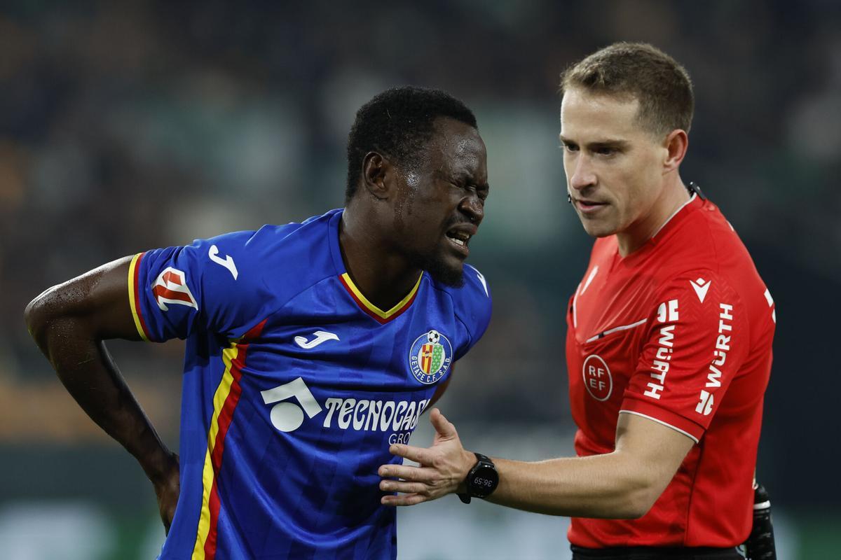 SEVILLA, 21/12/2025.- El defensa del Getafe Djené Dakonam (i) se duele tras una caída durante el partido de la jornada 17 de LaLiga EA Sports que Real Betis y Getafe CF disputan hoy domingo en el estadio La Cartuja, en Sevilla. EFE/ Julio Muñoz