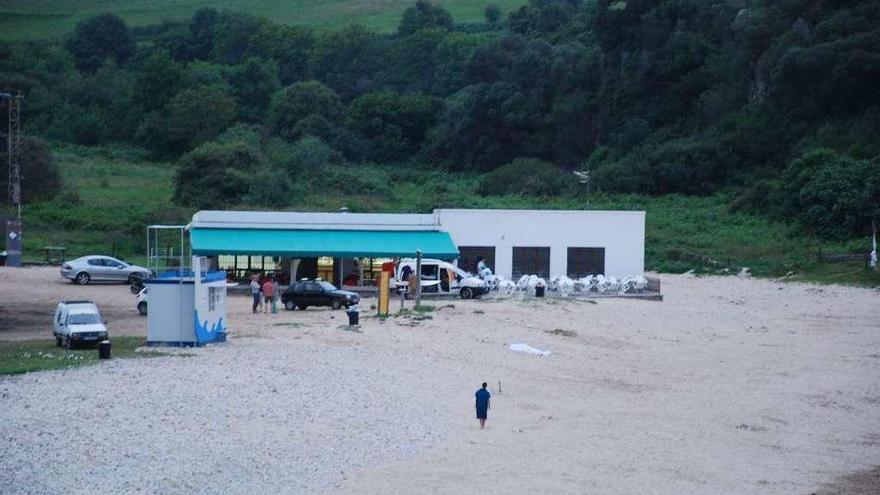 El cuerpo sin vida de Luis Américo García-Portilla cubierto con una sábana blanca en el lugar en el que se desplomó, en la playa de San Antolín, en Naves de Llanes, ayer, a las diez de la noche.