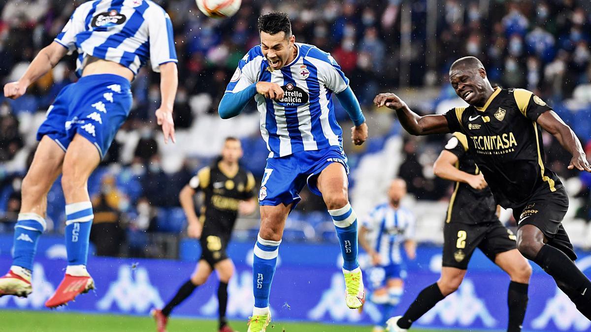 Miku, autor del gol de la victoria el pasado sábado frente al Sanse, remata de cabeza junto a su compañero Noel. |  // CARLOS PARDELLAS