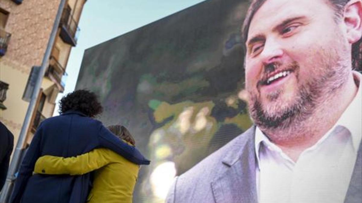 Marta Rovira se abraza a la también candidata Carme Forcadell bajo la mirada de Oriol Junqueras desde la pantalla, en el acto central en el Born.