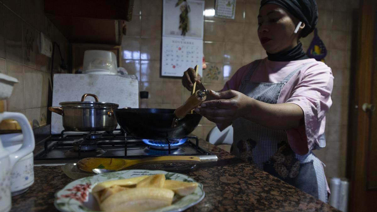 Olga, una mujer que sufre de pobreza energética, cocinando en su casa.