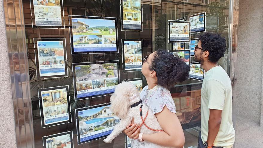 Una pareja ve anuncios de pisos en una inmobiliaria de Vigo. |   // MARTA G. BREA