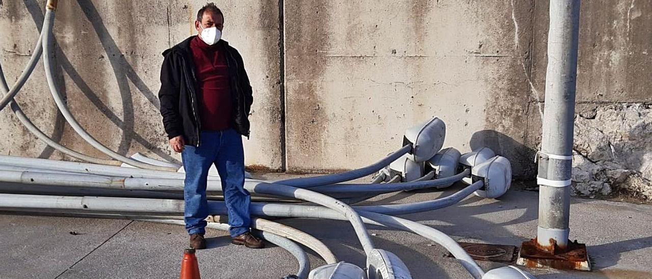 Ángel Batalla, junto a las viejas farolas que dejaron hace varias semanas de alumbrar en el puerto. | E. S. Román