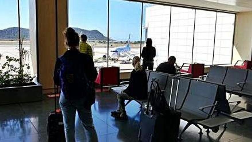 Un grupo de viajeros observa en el aeropuerto de Ibiza un avión que acaba de llegar desde Düsseldorf.