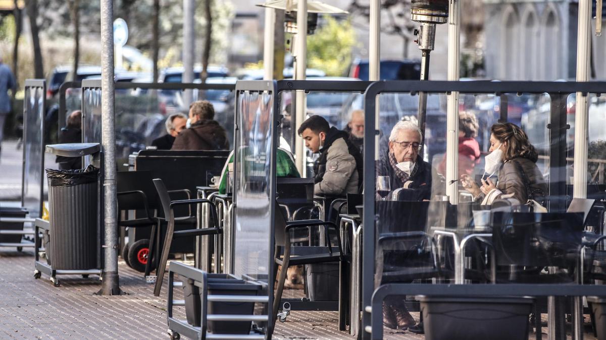 Imagen de clientes consumiendo en la terraza de un bar.