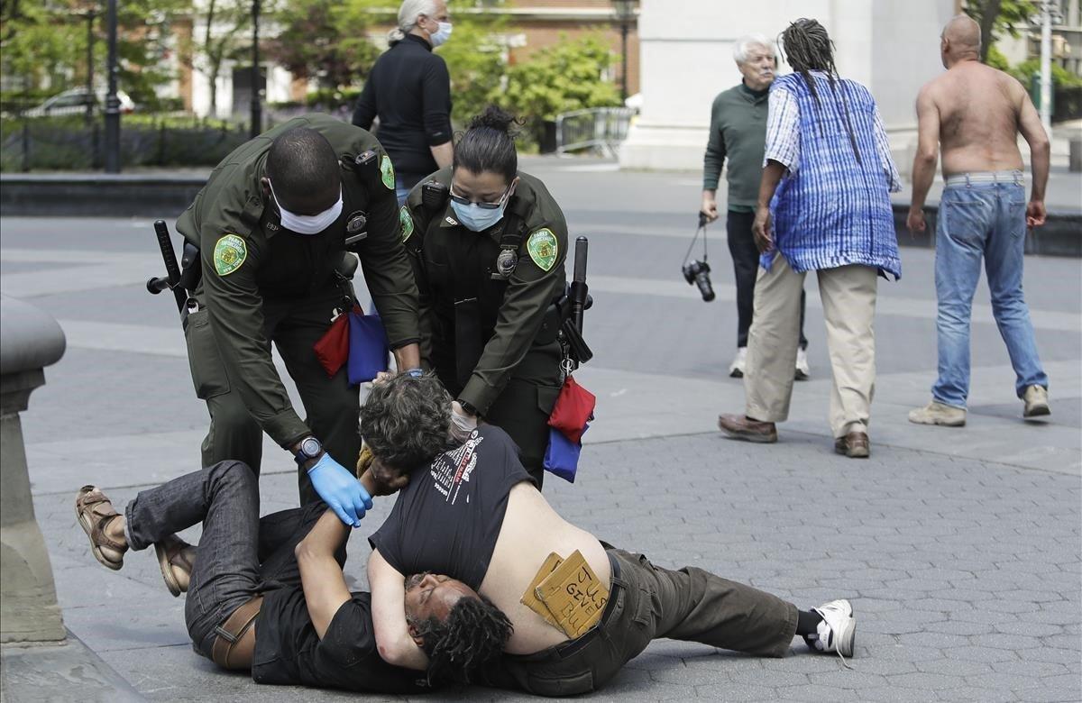Agentes de la policía separan a los dos individuos que se peleaban en el parque Washington Square.