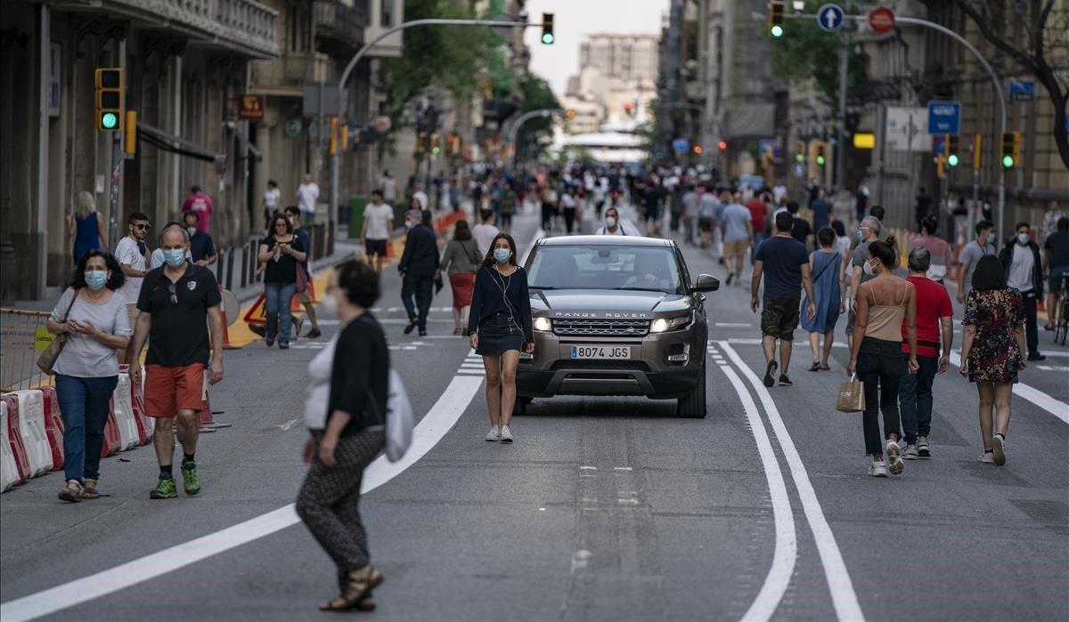 Son las 20.35 horas del 20 de mayo, el primer fin de semana que Barcelona cierra algunas calles al tráfico, cuando aparece la protagonista de la imagen, una joven absorta en su música, que pasea por el centro de la calzada en Via Laietana, ajena al conductor despistado que intenta abrirse paso entre los viandantes. La calle, ahora sí, es de ella.