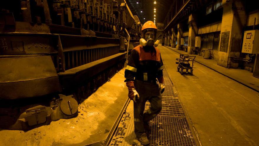 Un empleado de Alcoa junto  a una de las líneas de cubas que se va a parar.