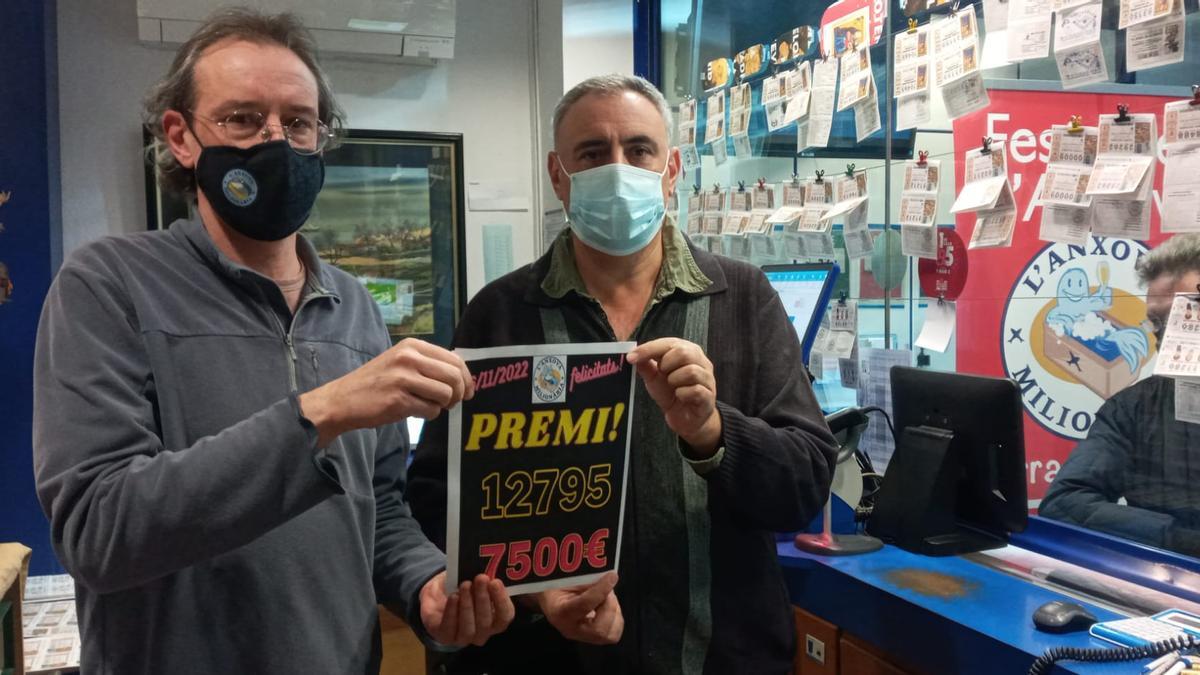 Dos treballadors de l&#039;administració l&#039;Anxova Milionària amb un cartell anunciant el premi