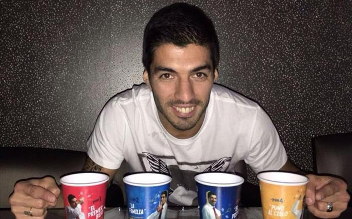 Luis Suárez muestra los cuatro vasos solidarios
