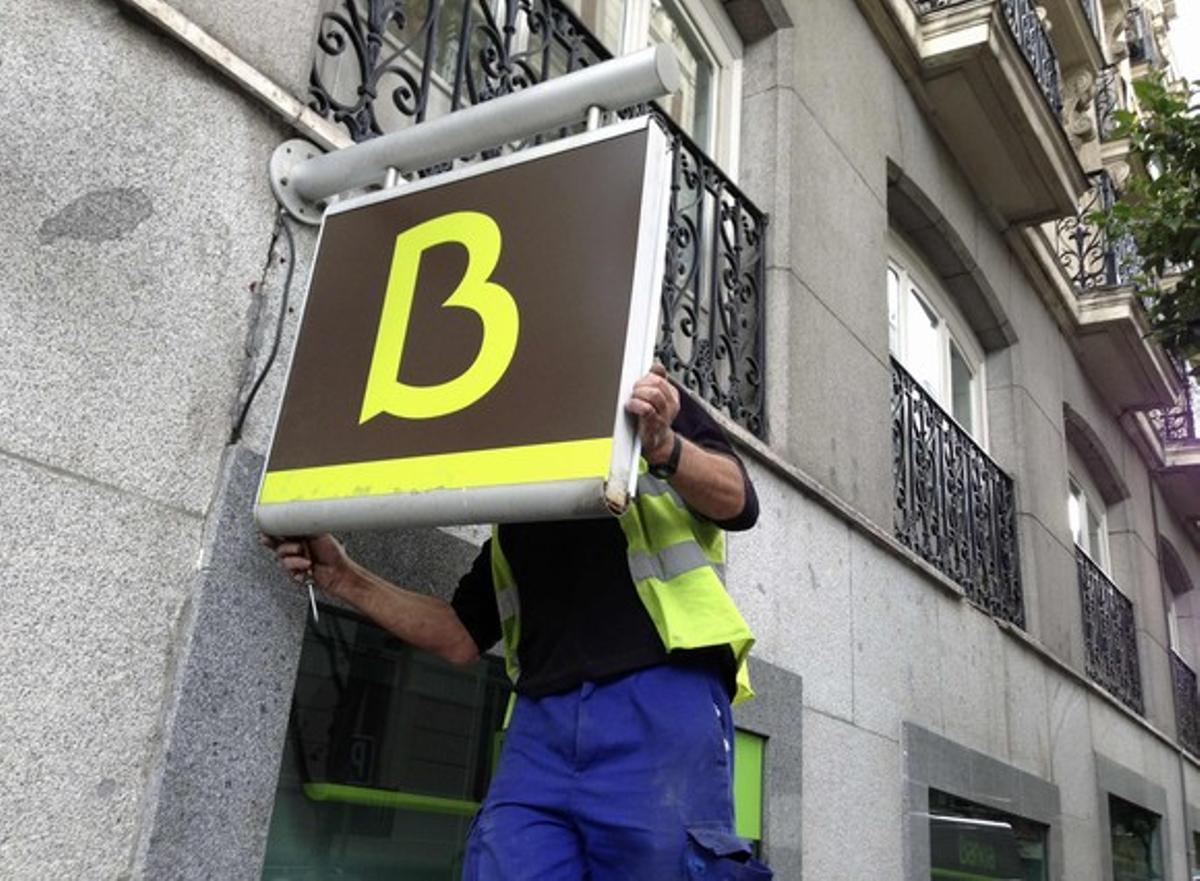 Un treballador col·loca el logo de Bankia en una oficina de l’entitat a Madrid. Un treballador col·loca el logo de Bankia en una oficina de l’entitat a Madrid.